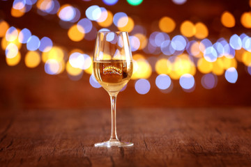Glass of wine on wooden table and bokeh background