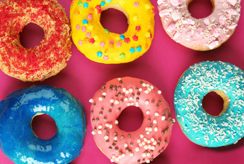Glazed donuts on color background
