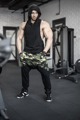 Naklejka na ściany i meble Strong man posing in gym