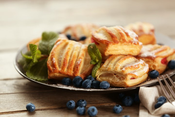 Sweet tasty pastries with bilberries on plate, closeup