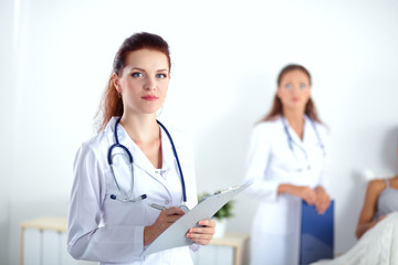 Fototapeta premium Woman doctor with folder standing at hospital