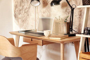 Workplace with laptop on table in modern room