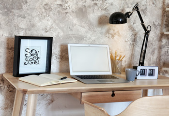 Workplace with laptop on table in modern room