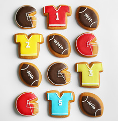 Delicious gingerbread cookies decorated with football signs on white background
