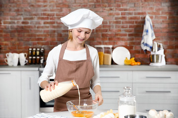 Cute girl cooking in kitchen at home