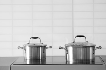 Metal pans on modern kitchen stove