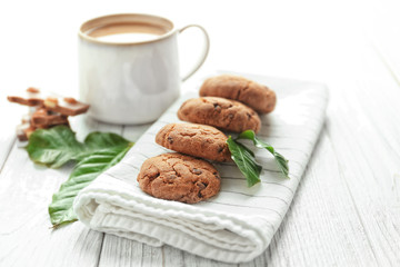 Napkin with tasty homemade cookies and cup of coffee on wooden table