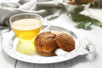 Tray with tasty homemade cookies and cup of tea, closeup