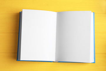 Opened book on yellow wooden table