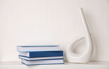Stack of books on white wooden shelf