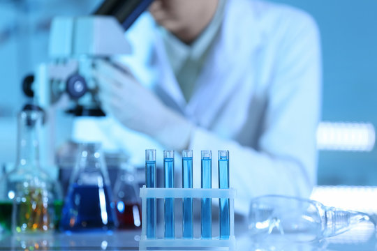 Test tubes with blue samples on laboratory background