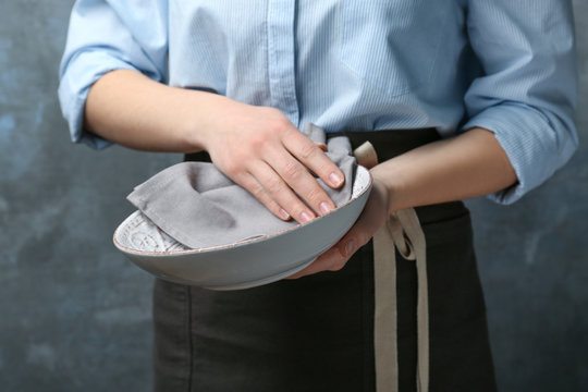 Woman wiping plate with napkin, closeup