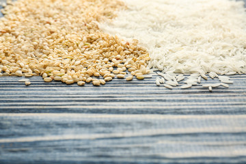 Different kinds of rice on wooden background