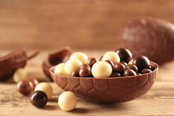 Chocolate Easter eggs and candies on wooden background