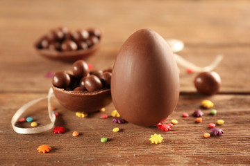 Chocolate Easter eggs and candies on wooden background