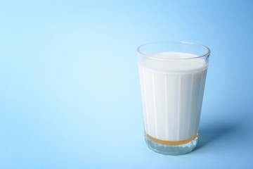 Glass of milk with honey on blue background