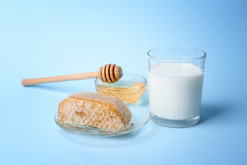 Composition with milk, honey and honeycomb on blue background
