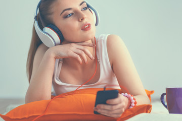 Naklejka premium Young woman lying on floor and listen to music