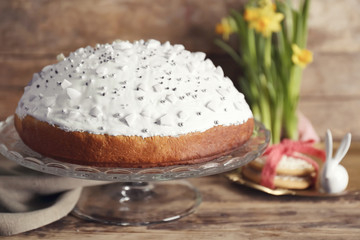 Tasty Easter cake with decorations on wooden background