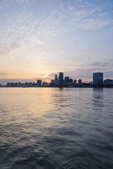 Obraz premium City Skyline By River Przeciw zachmurzonemu niebu w Szanghaju w Chinach.