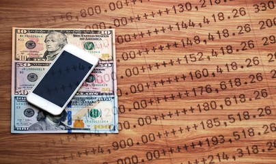 Mobile phone on dollar cash banknote and statement, digital money and finance concept, double exposure