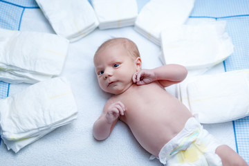 newborn baby on changing table with diapers