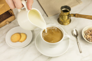 Milk poured into cup of coffee