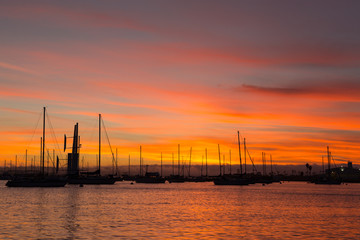 Fototapeta na wymiar Pink, yellow, red, orange sunset sky in California, San Diego. Sailboats, boats. Silhouette