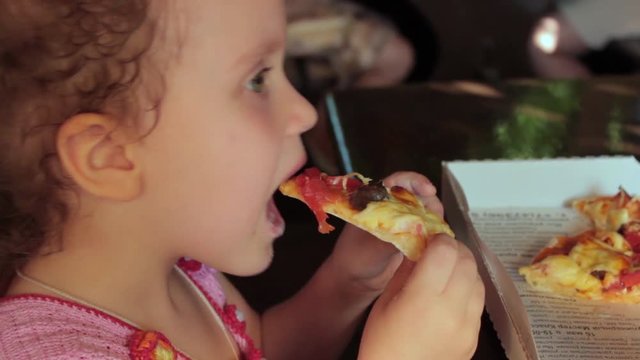 Little girl eating pizza, portrait