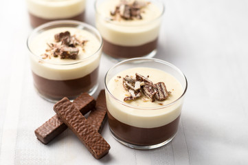 No-bake layered chocolate mousse and cheesecake with chocolate covered wafer cookie crumbs topping. In clear glass dessert bowls. On white background. Great recipe, creamy, light and not too sweet!