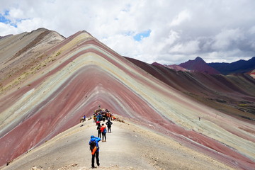 rainbow mountain with hiker at peru