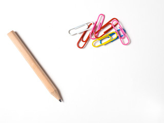 Paper clips and pencil on white background.