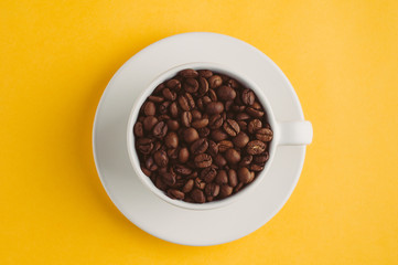 Cup with coffee grains  on a yellow background