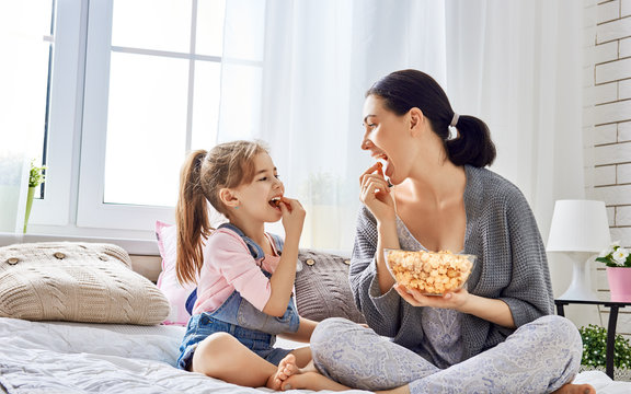 Mother And Daughter Eating Popcorn