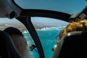 Helicopter Flight at 12 Apostles. Helicopter flight at famous "12 Apostles", Great Ocean Road, Australia. Taken from the inside, two women sitting in the front of the cockpit.