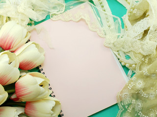 empty note book opening with lace decor and artificial tulip flower background