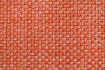 Bright orange textile background with checkered pattern, closeup. Structure of the fabric macro.