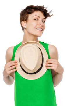 Happy smiling woman posing in a studio with a hat