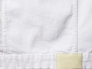 White denim textile for background closeup with empty label