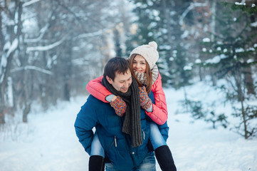 Fototapeta na wymiar woman and man having fun in winter forest