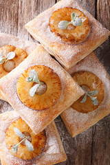 Freshly baked puff pastry pies with pineapple close-up. vertical top view