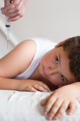 fat little kid lies on a background of hand with syringe