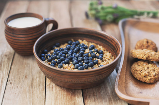 Oatmeal porridge with blueberries, milk and cookies, healthy food concept