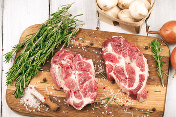 Porky steak with spice and herb on wood background