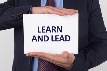 Man showing paper with LEARN AND LEAD text
