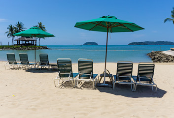 Lounge chairs with sun umbrella on a beach in Kota Kinabalu, Sabah Borneo, Malaysia.