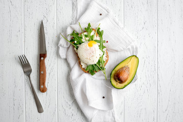 sandwich with poached eggs on wooden background top view