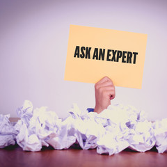 HAND HOLDING YELLOW PAPER WITH ASK AN EXPERTCONCEPT