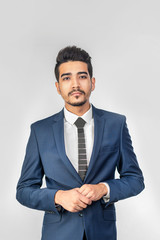 Young attractive man in a blue suit on a gray background. Isolated