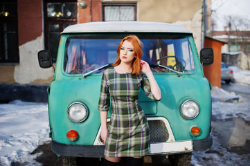 Young red haired girl posed on checkered dress background old re